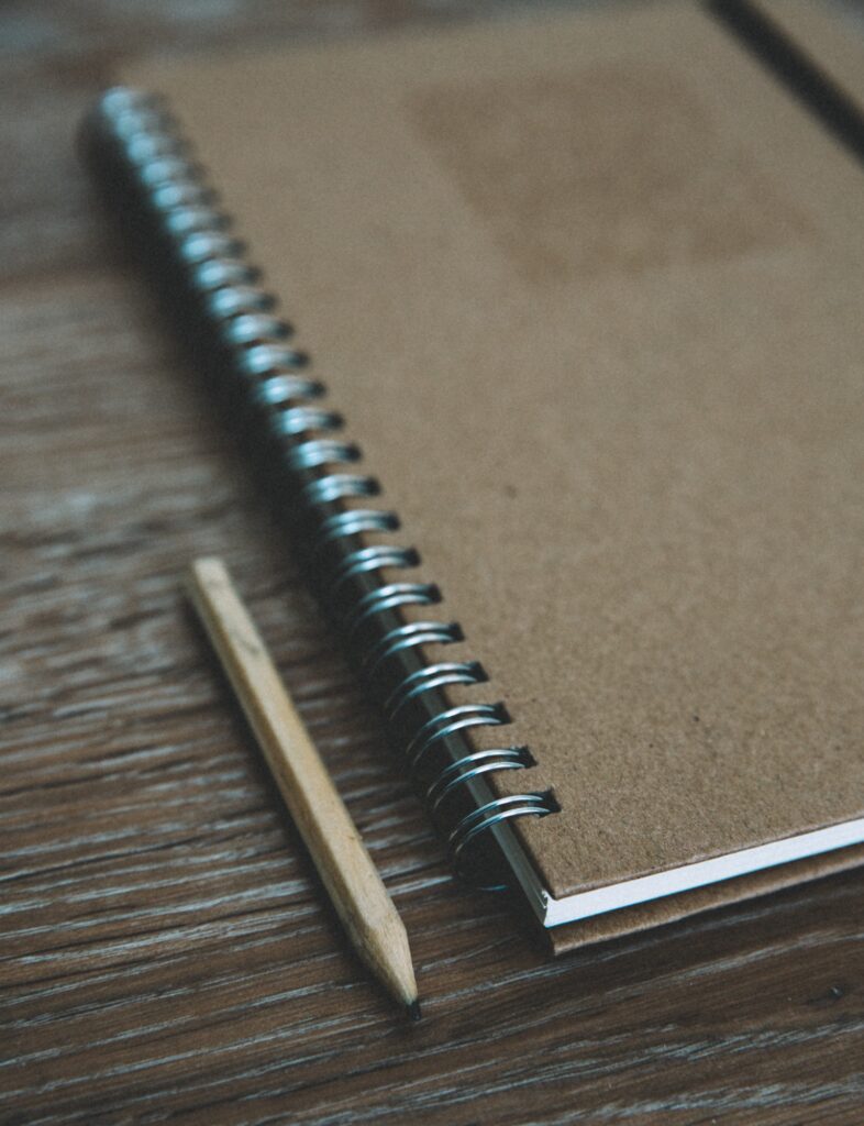An old fashioned or vintage notebook and pencil with ring binder and copy space