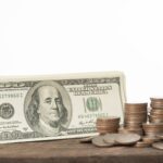 Close up of dollars and coins for currency exchange on white background.