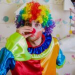 Clown pushes himself on the nose.