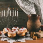 traditional jewish menorah, ceramic jug, Hanukkah gelt, gifts and donuts for hanukkah celebration